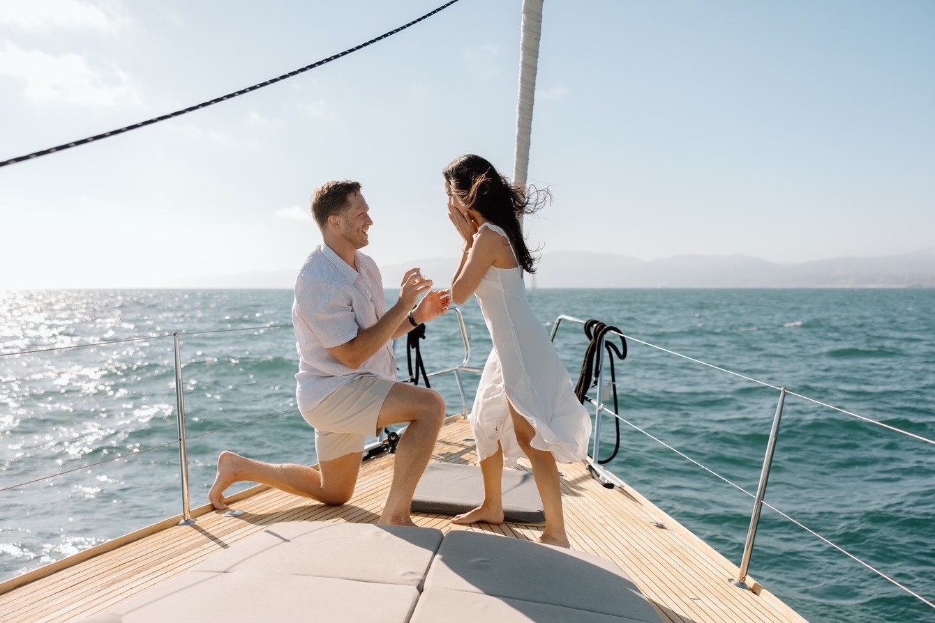 Marriage proposal setup on yacht deck at sunset with roses and champagne